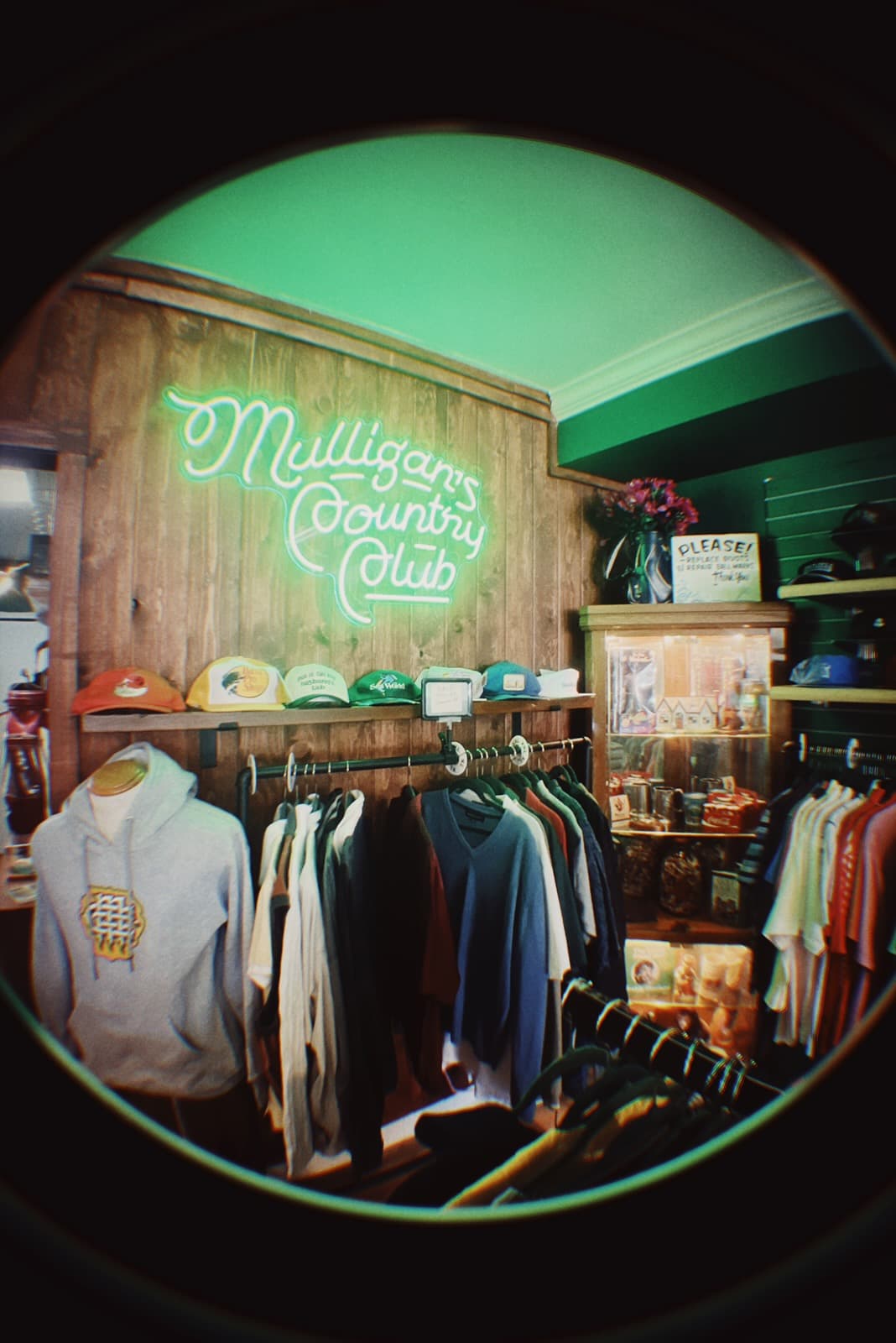 Inside the Mulligan's Country Club pro shop — neon sign, vintage gear on the rack