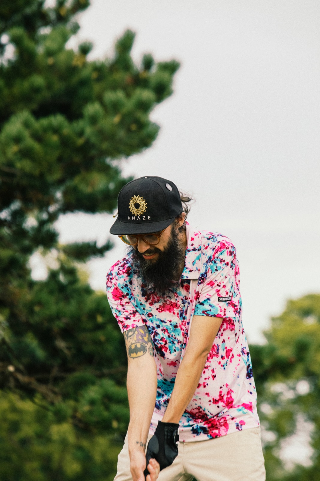 Golfer in a loud pink floral shirt mid-swing
