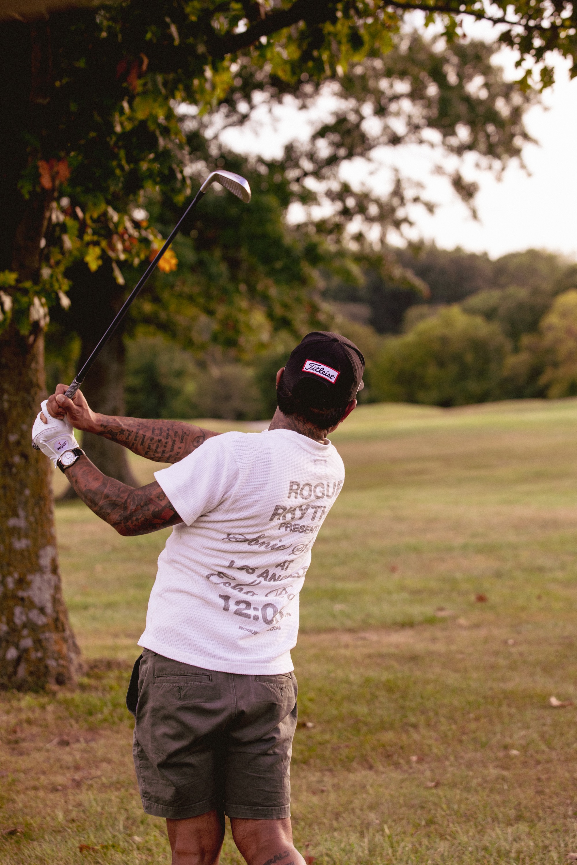 Golfer in graphic tee mid-backswing