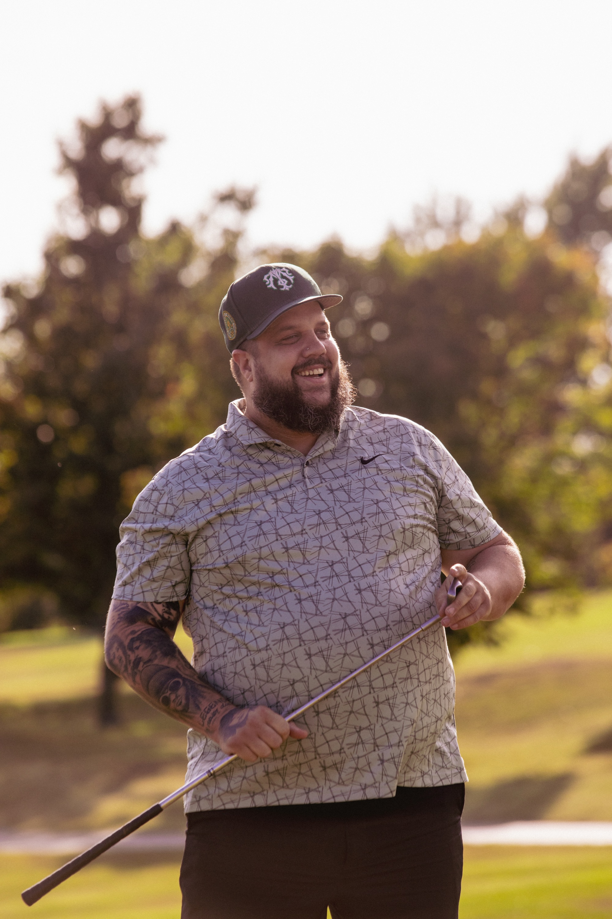 League member laughing on the course at golden hour