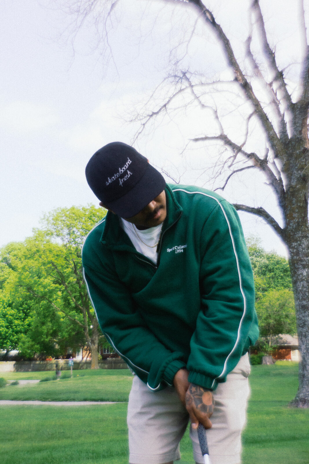 Putter in green Sport College quarter-zip and skateboard cap
