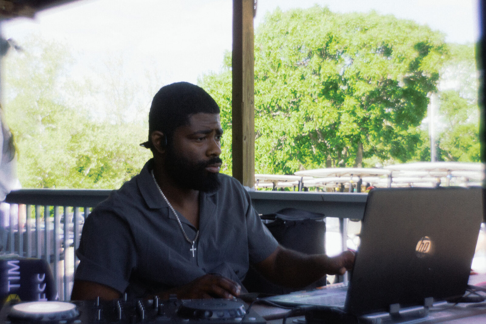 DJ at the league behind his laptop and decks on the patio