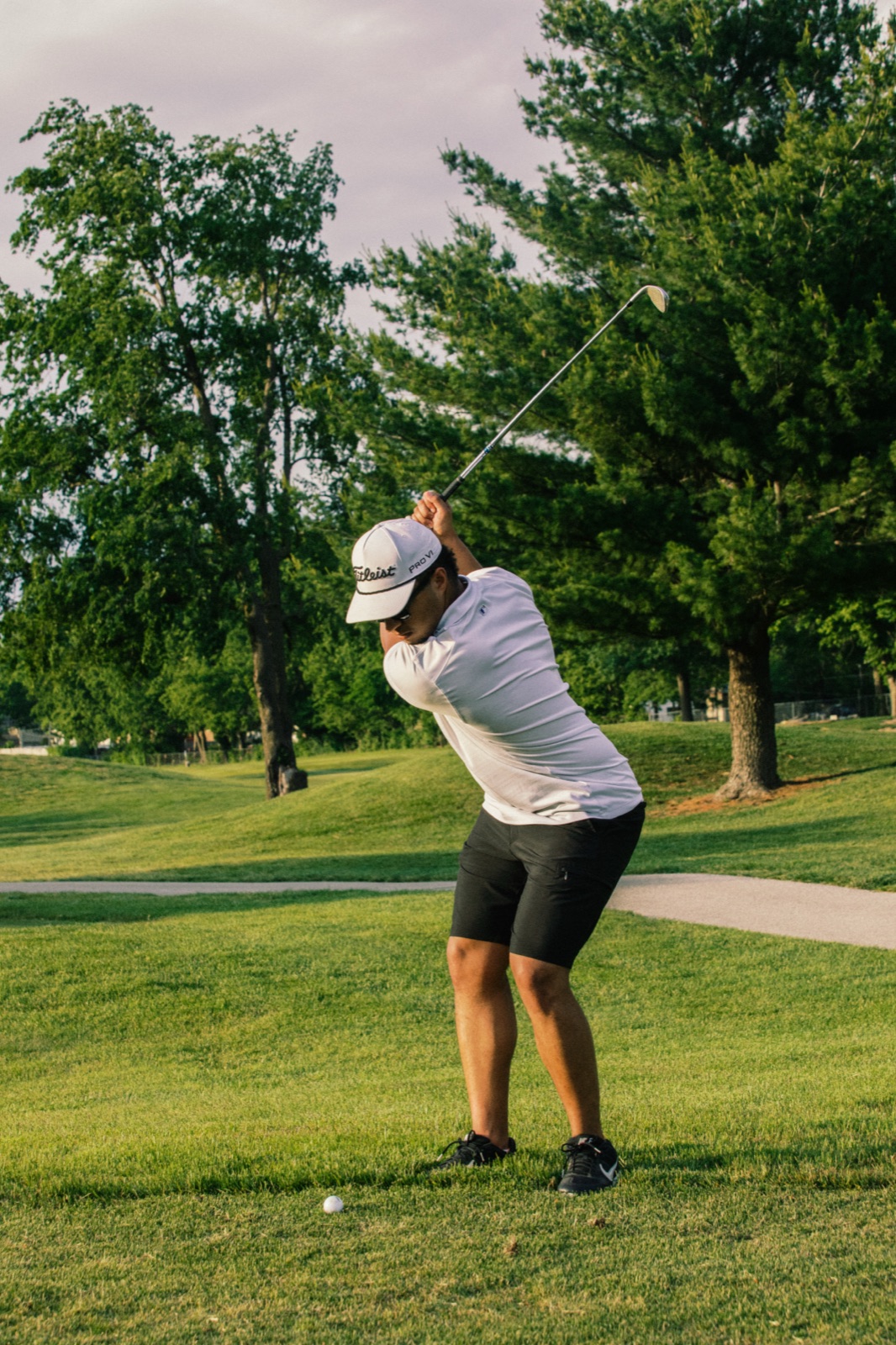 Golfer's full follow-through in the evening light