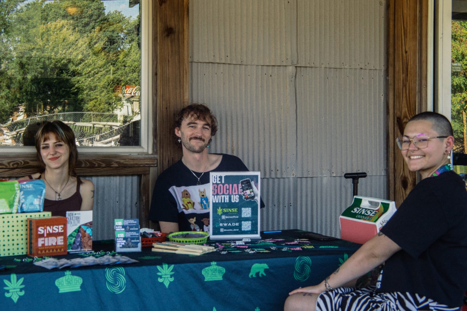 Three league members at the check-in table under the clubhouse porch
